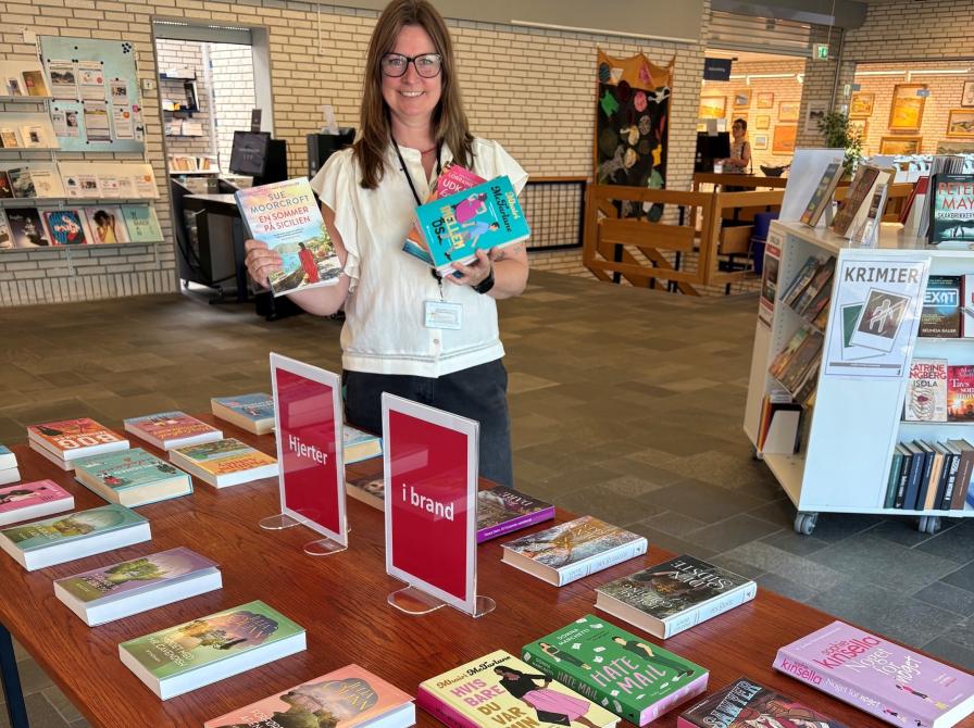 Dorthe viser bøger frem fra udstillingen 'Hjerter i brand'